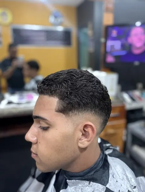 Degradê baixo com o cacheado curto, de perfil